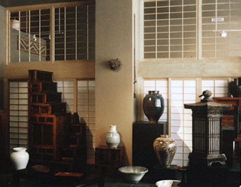 Set between large structural columns, these shoji screens provide the perfect background for Japanese antiques.