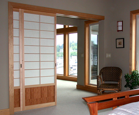 Pocket door shoji screen room dividers separate the master bedroom from the living area